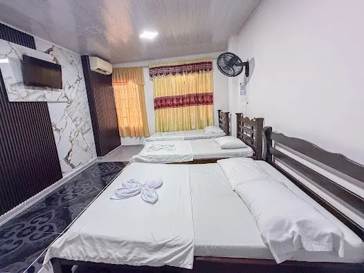Habitación con aire acondicionado, TV y tres camas